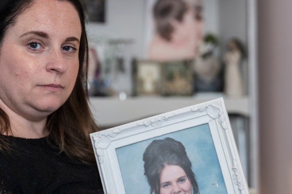 Joanne Good sitting down holding photograph of her daughter Megan.